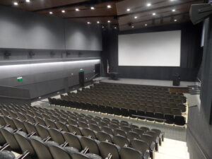 white square film screen with rows of black seats