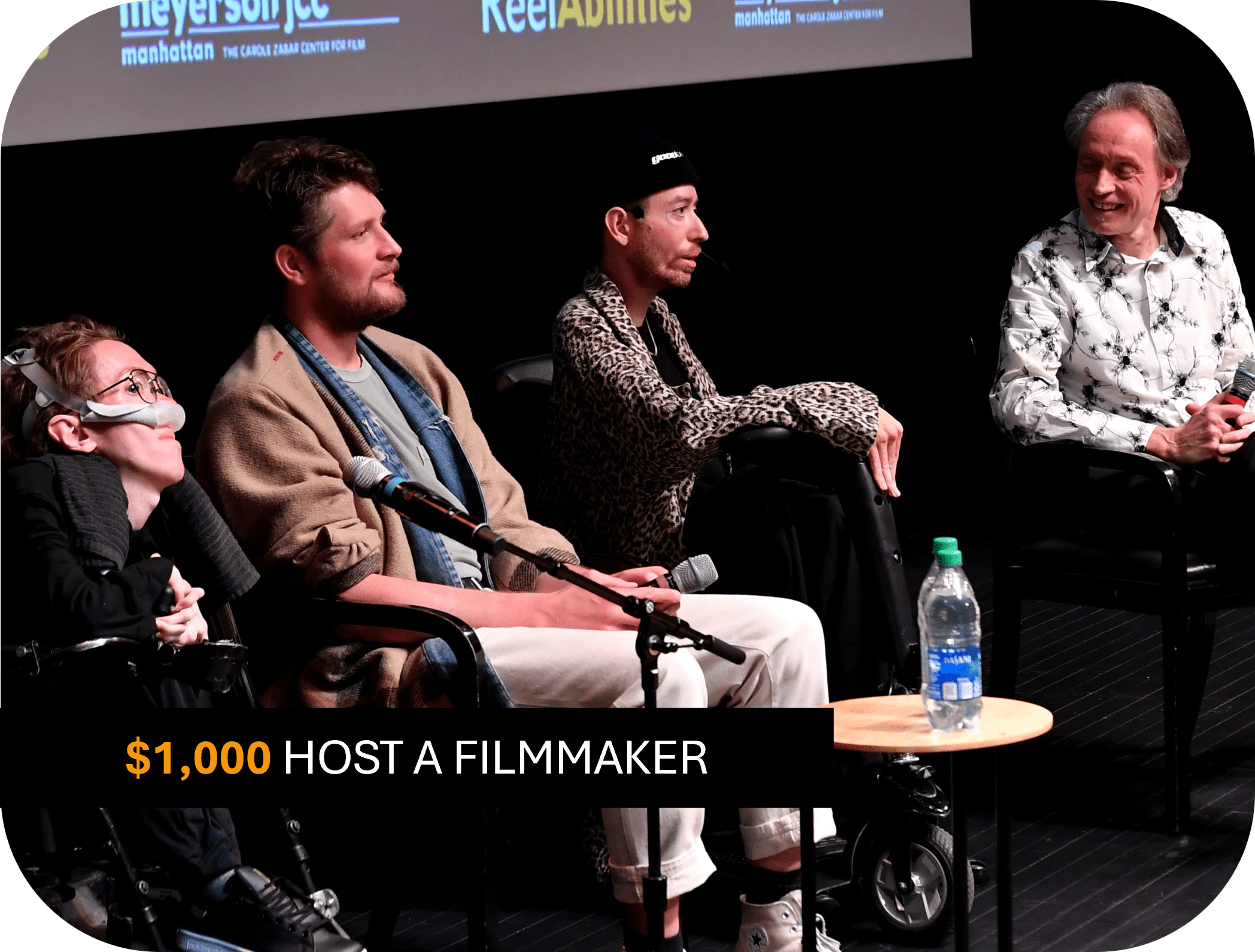 4 men on stage, the moderator is smiling at the panelists - two of them using a wheelchair. Text reads: $1,000 host a filmmaker